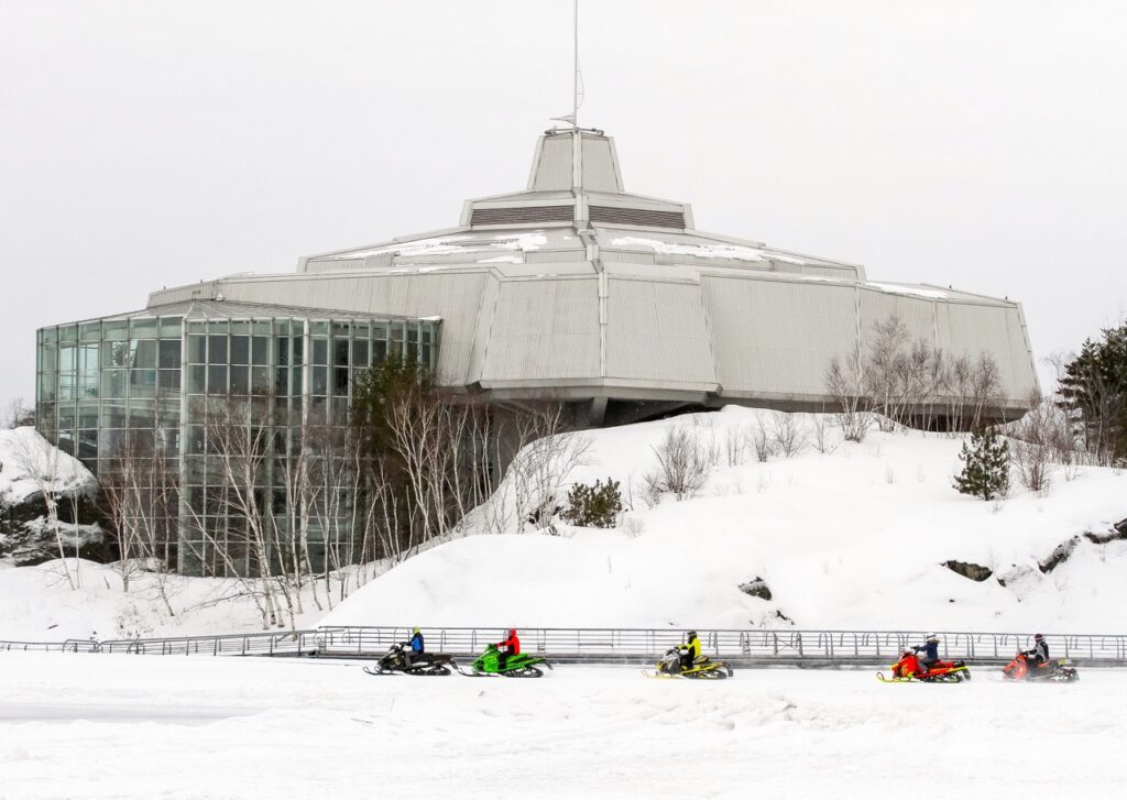Sudbury Snowmobiling Snapshot shows snowmobiles in front of Science North